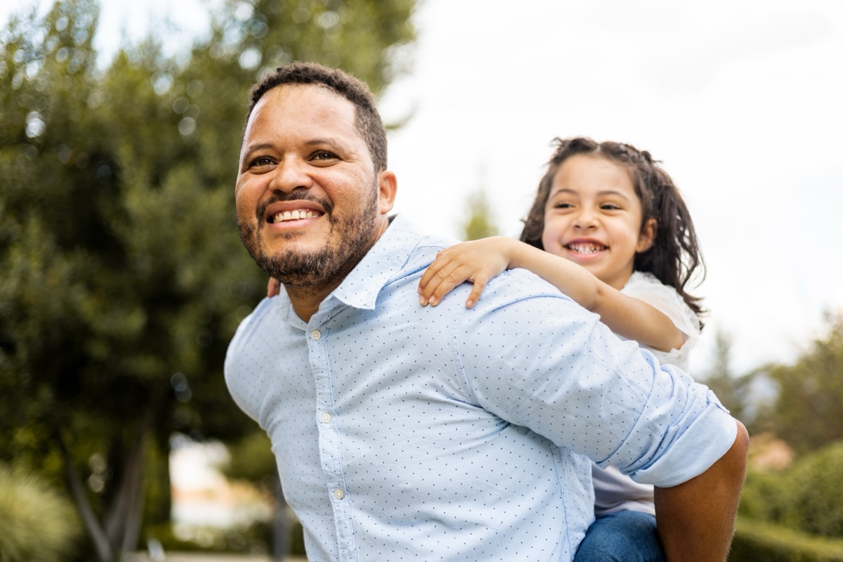 father giving daughter a piggy-back ride