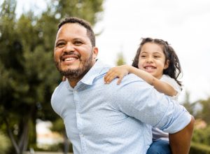 father giving daughter a piggy-back ride