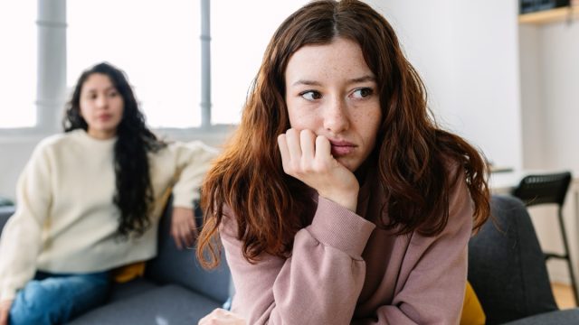 two female friends sitting separately after arguing