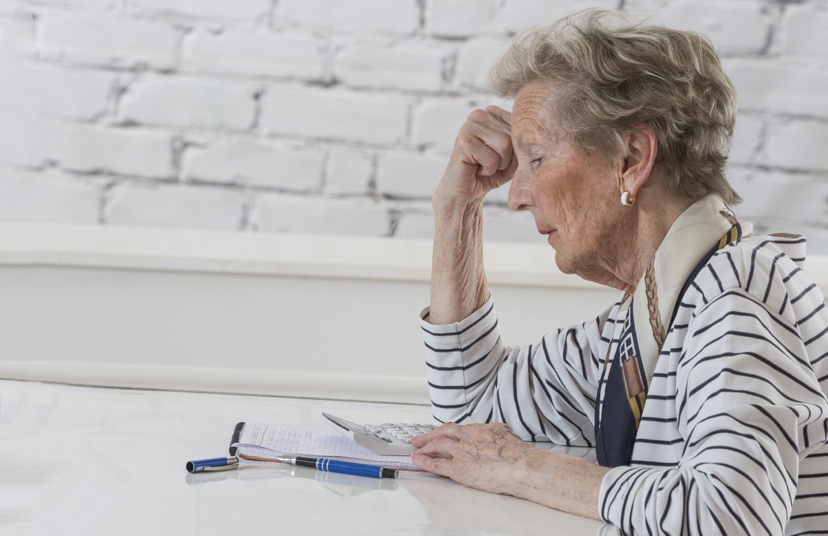 frustrated older woman calculating finances
