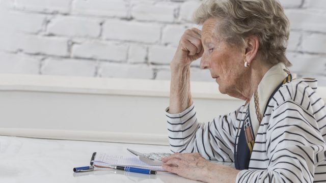 frustrated older woman calculating finances