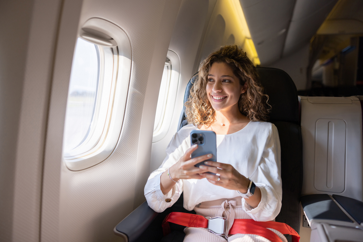 A woman sitting in a business class seat on a plane