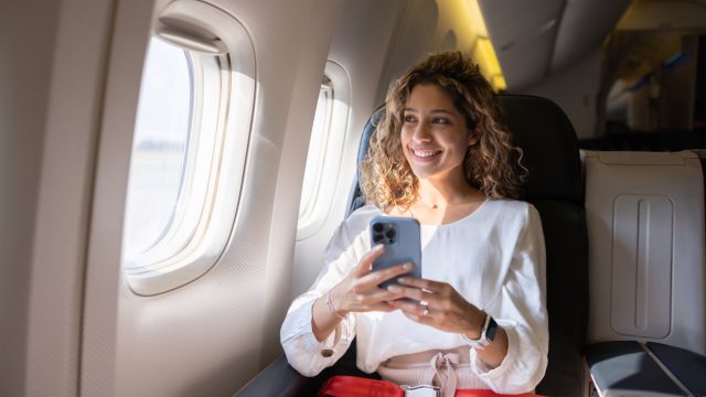 A woman sitting in a business class seat on a plane