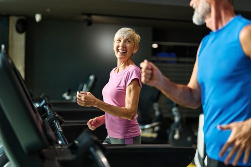 Portrait of a senior woman exercising in a gym, mature couple running using threadmill machine equipment, healthy lifestyle and cardio exercise at fitness club concepts, vitality and active senior