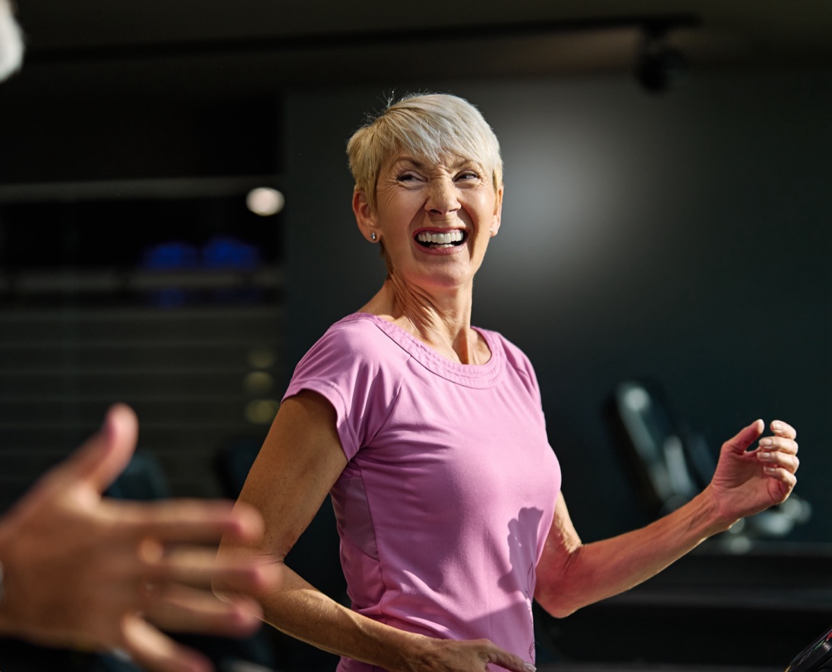 Portrait of a senior woman exercising in a gym, mature couple running using treadmill machine equipment, healthy lifestyle and cardio exercise at fitness club concepts, vitality and active senior