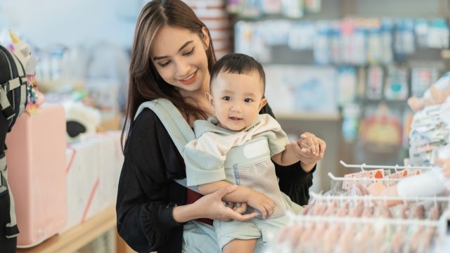 Young mother with her baby shopping in a baby store