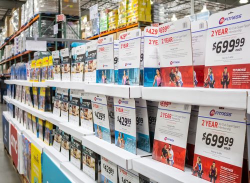 A view of several varieties of gift cards and discount deals on display at a local Costco.