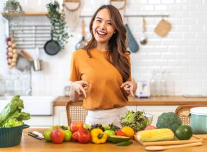 Portrait of beauty body slim healthy asian woman having fun cooking and preparing cooking vegan food healthy eat with fresh vegetable salad on counter in kitchen at home.Diet concept.Fitness, healthy