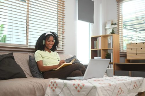 woman listening to playlist while writing in journal