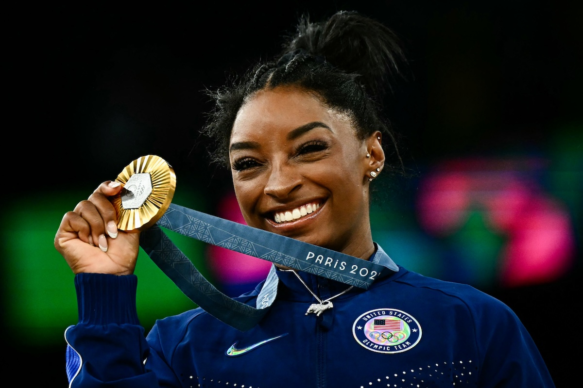 US' Simone Biles poses with her gold medal during the podium ceremony after the artistic gymnastics women's all around final during the Paris 2024 Olympic Games at the Bercy Arena in Paris, on August 1, 2024. (Photo by Loic VENANCE / AFP)