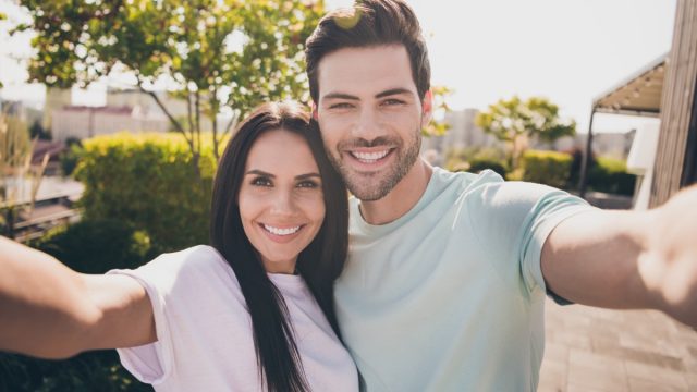 Photo of lovers couple take selfie look camera toothy shiny smile wear casual clothes in garden park outdoors