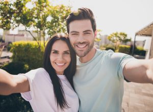 Photo of lovers couple take selfie look camera toothy shiny smile wear casual clothes in garden park outdoors
