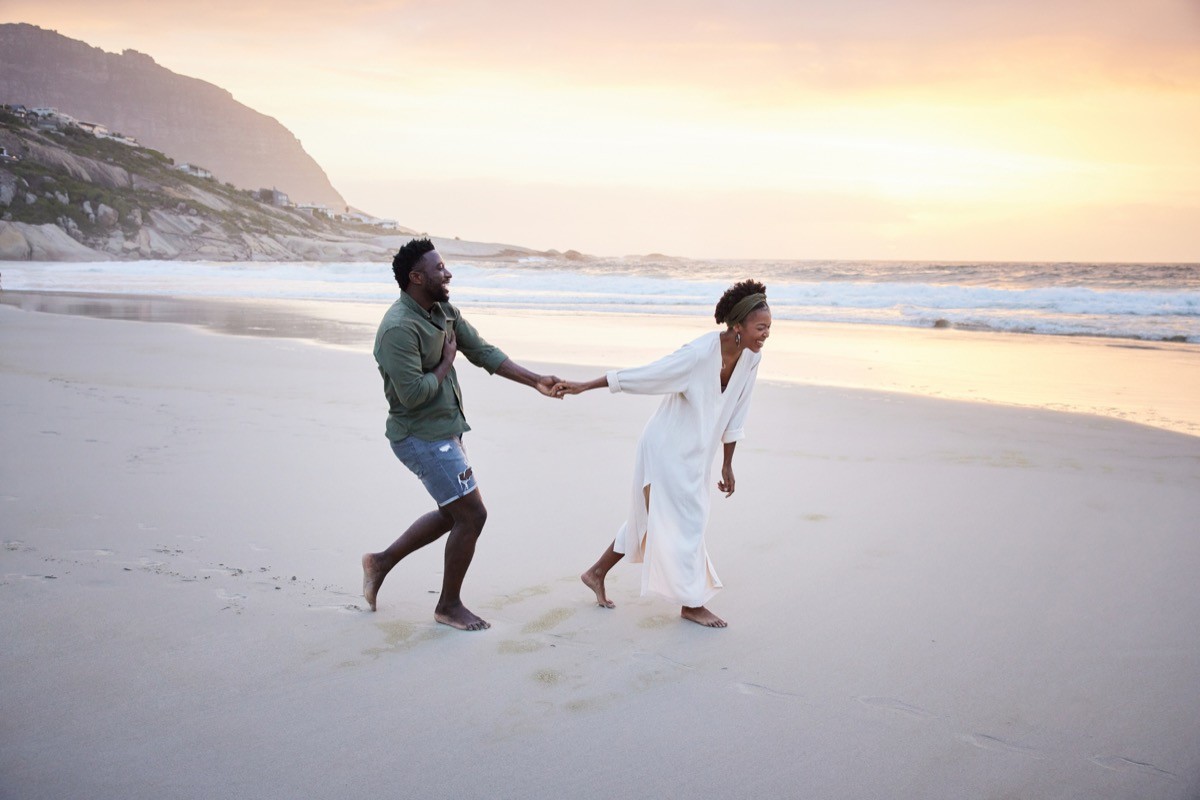 couple holding hands walking on the beach