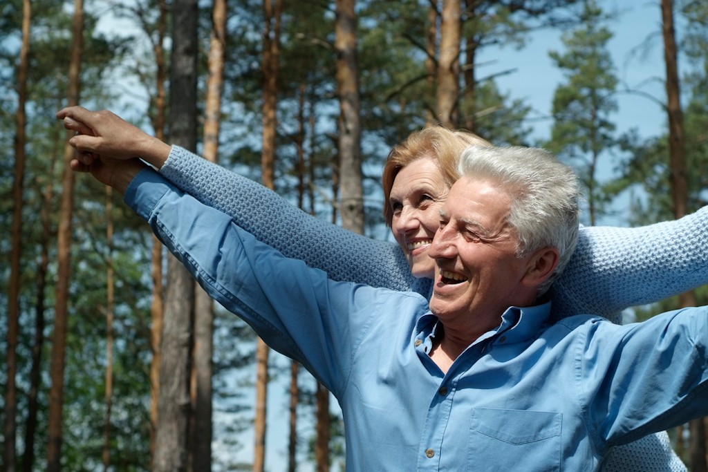 two happy mature adults in a forest