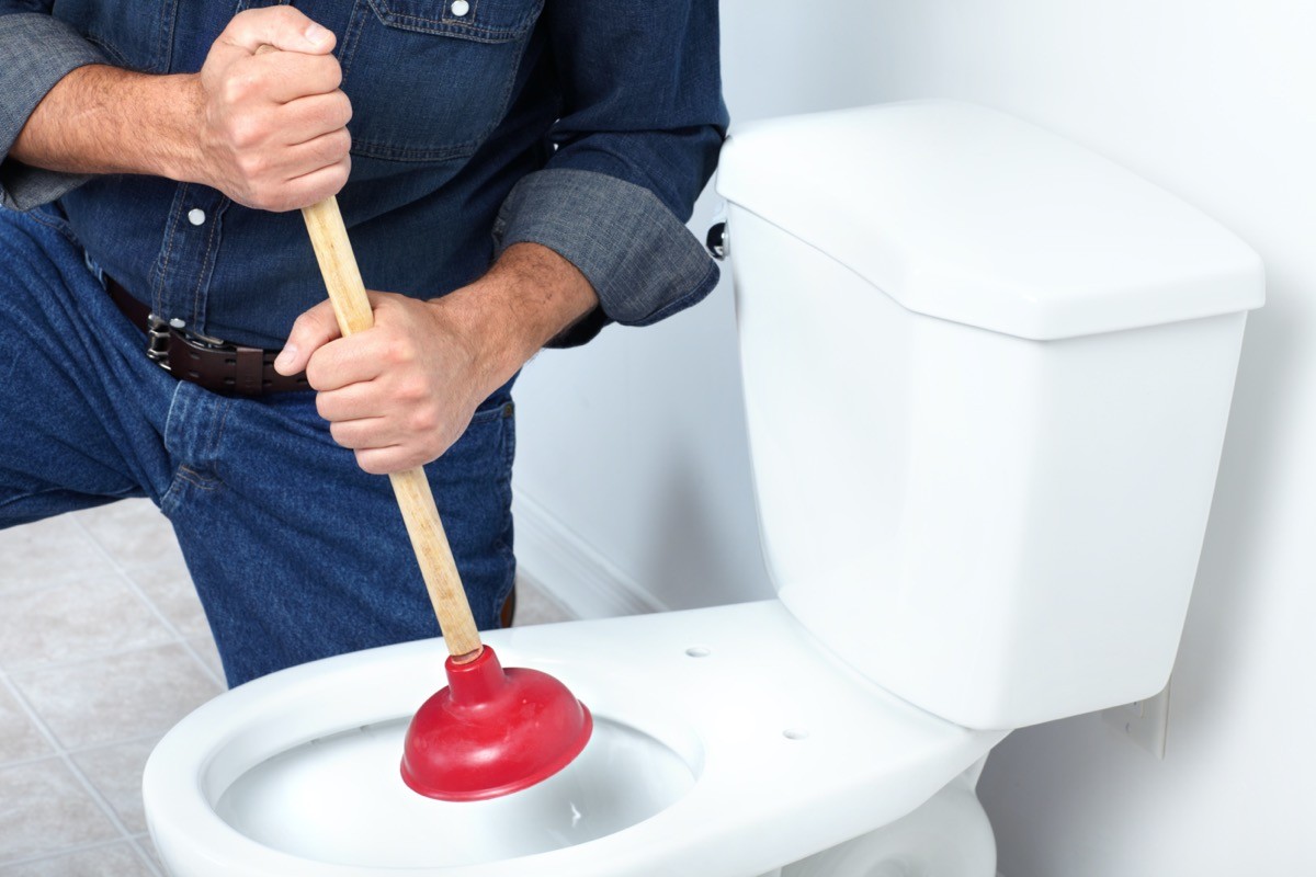 plumber plunging toilet