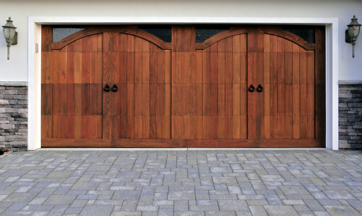 Gorgeous wooden garage doors with custom paved driveway. 