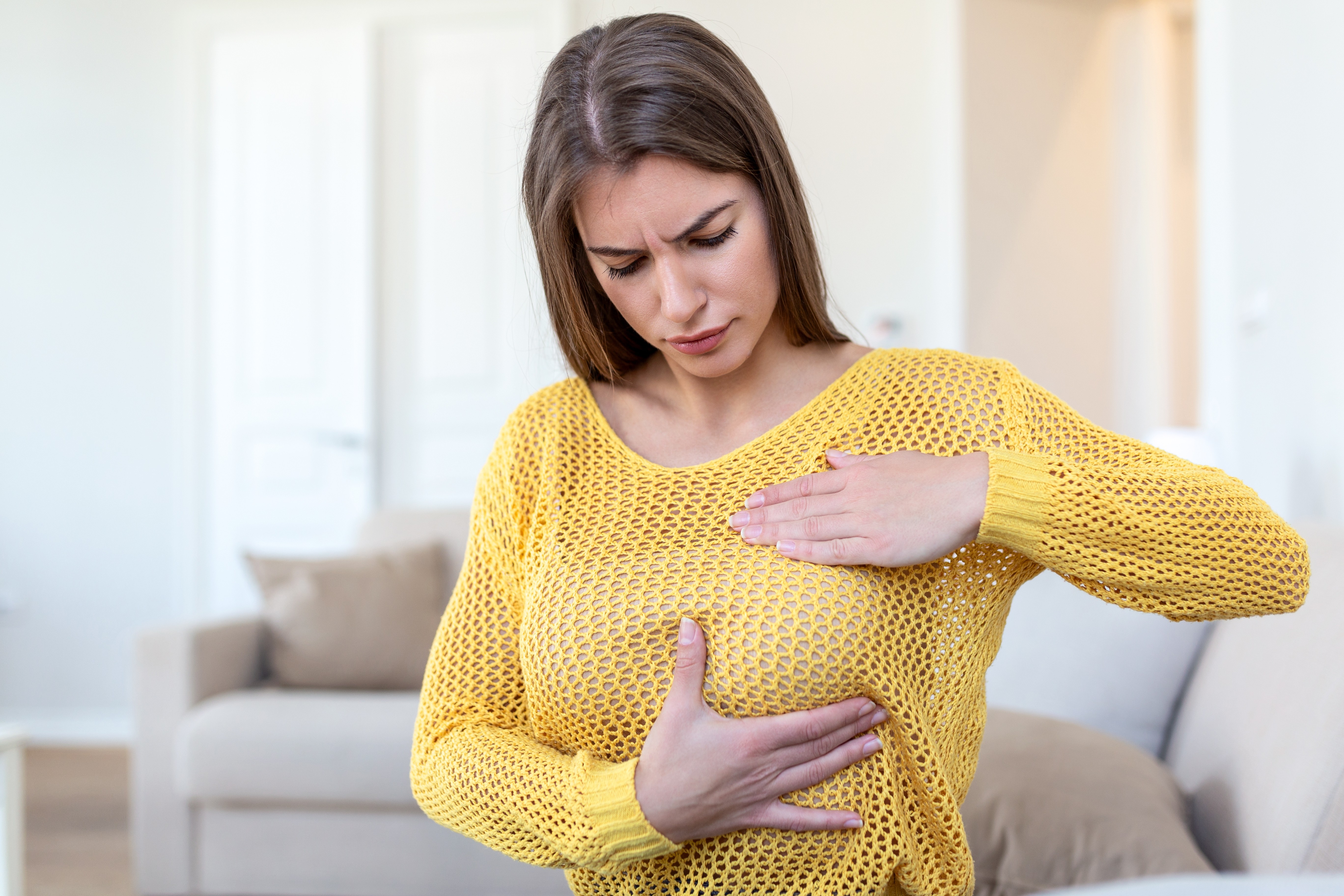 Woman experiencing pain in her breast.