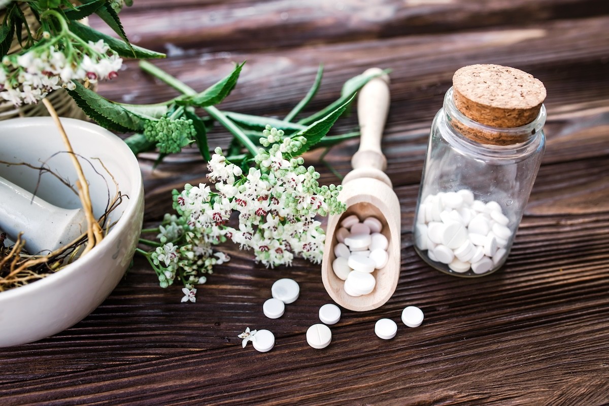 valerian root plant and valerian root supplements on a wooden table