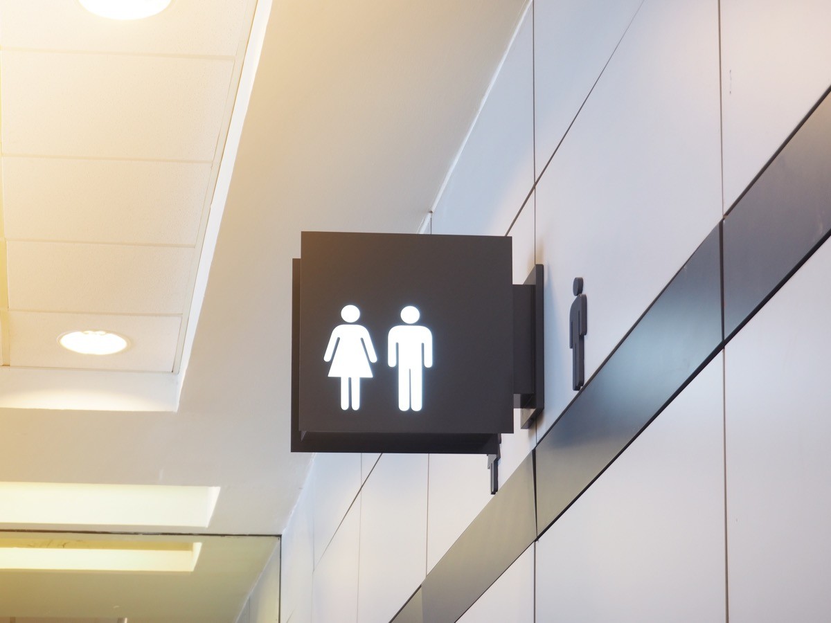 A bathroom sign above a public restroom
