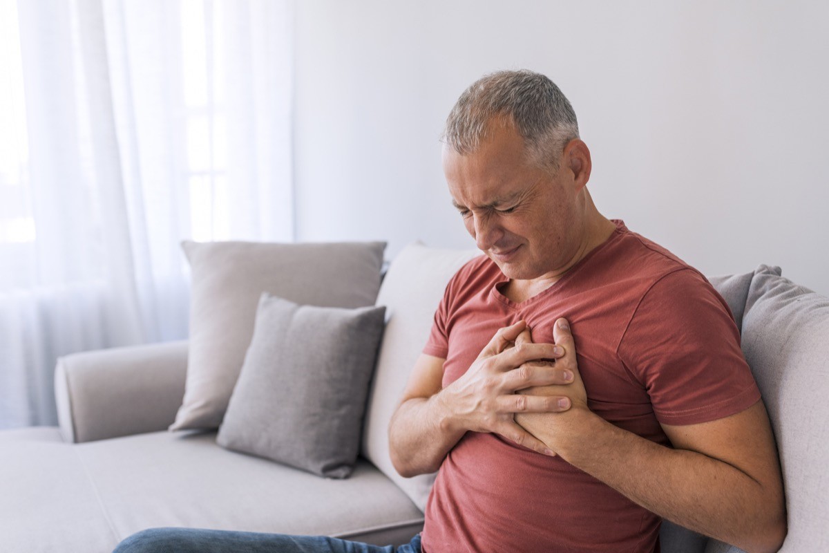 Man holding chest with pain from heartburn