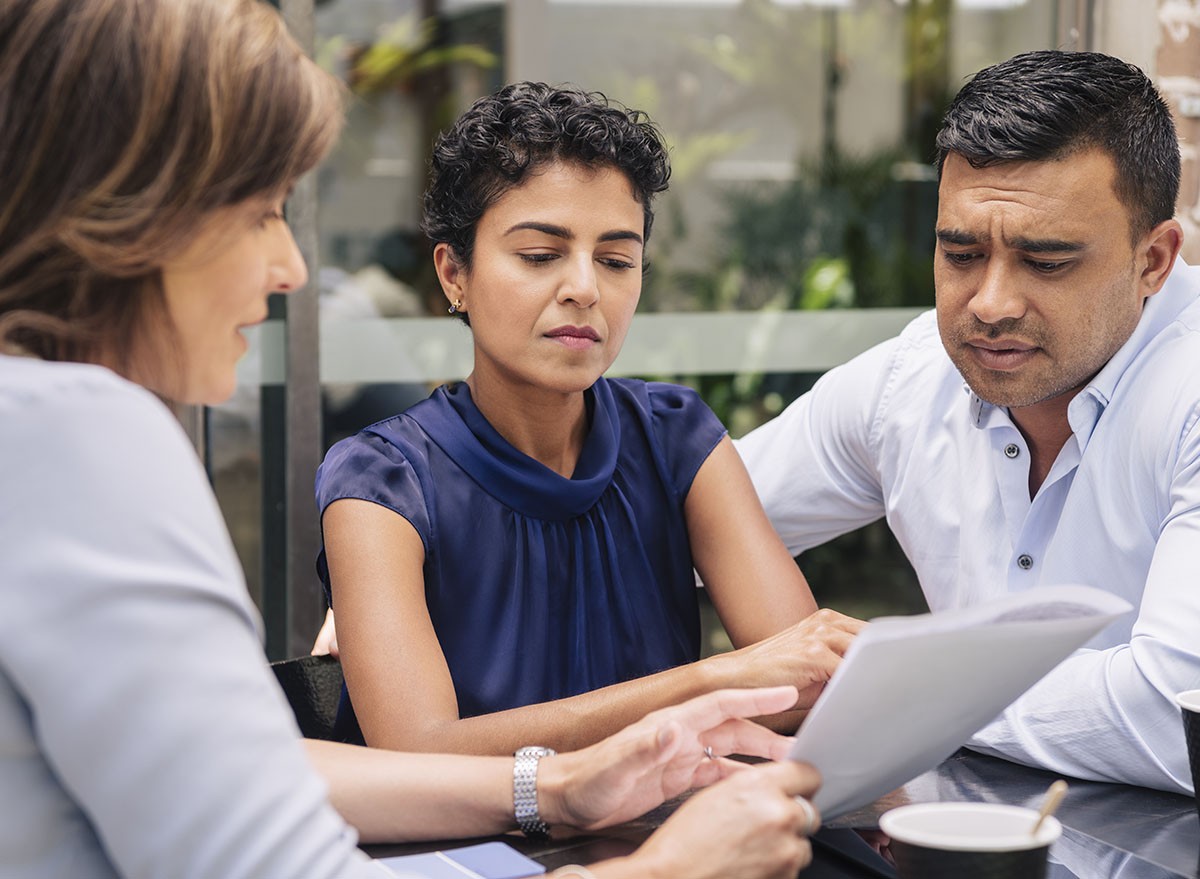 A financial advisor shows a couple some paperwork.