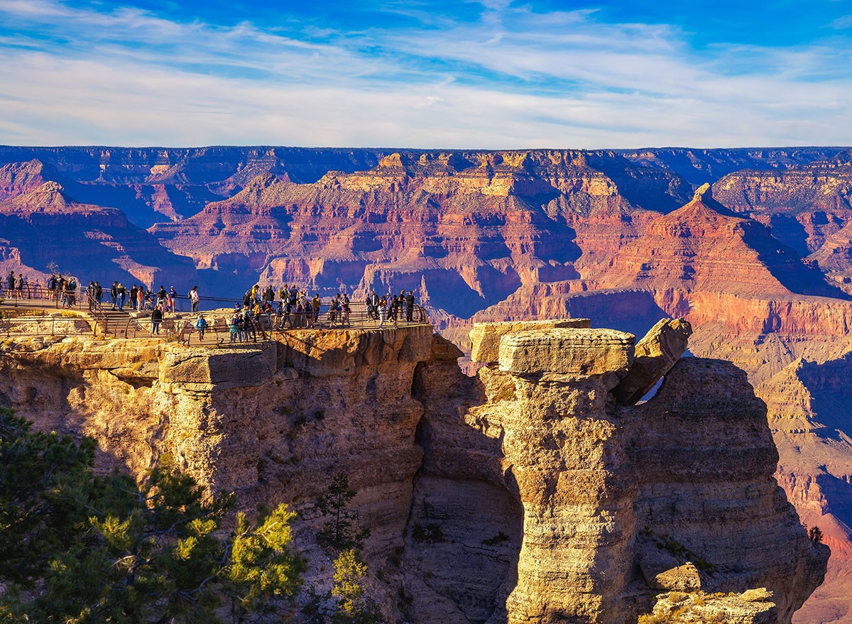 Tourists enjoy beautiful sunset above Grand Canyon National Park from Mather Point.