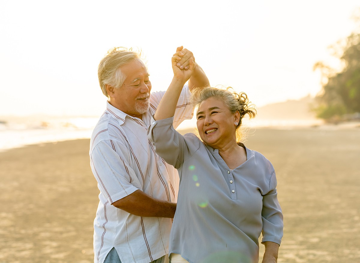 Senior Japanese couple dancing on the beach