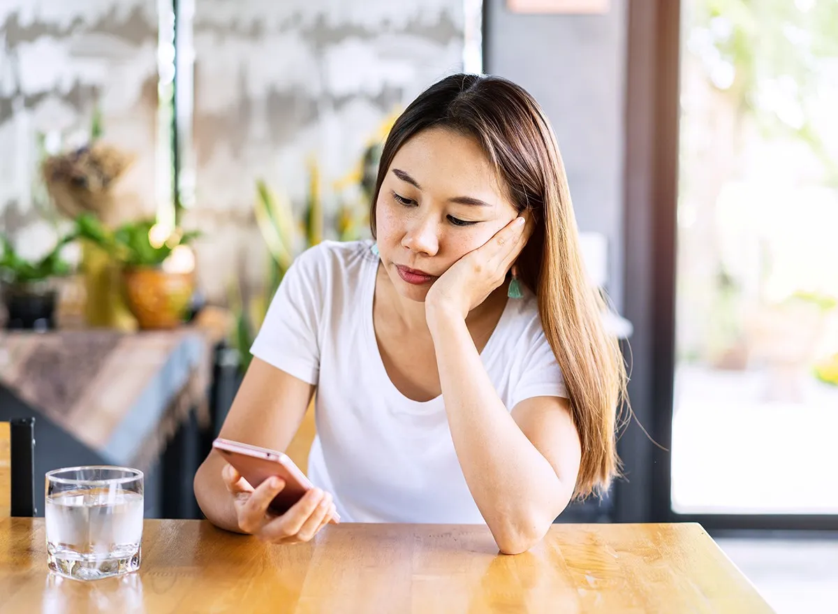 Woman at a table looking at her phone