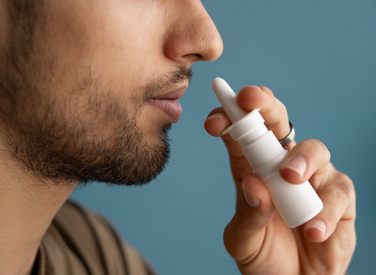 Man using a bottle of nasal spray