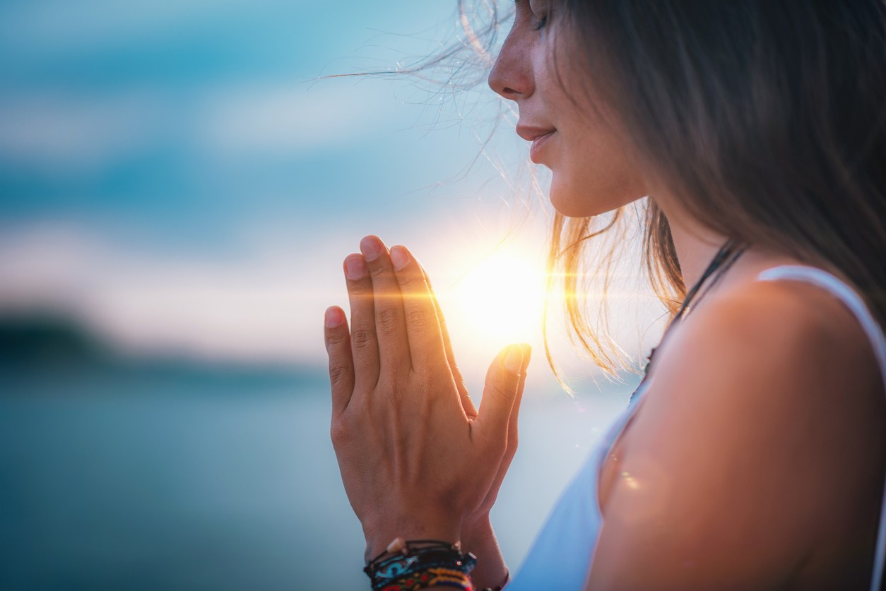 Young woman meditating in the morning sunlight