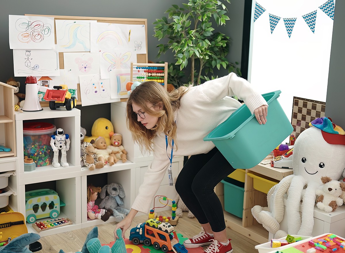 Woman picking up children's toys off the floor