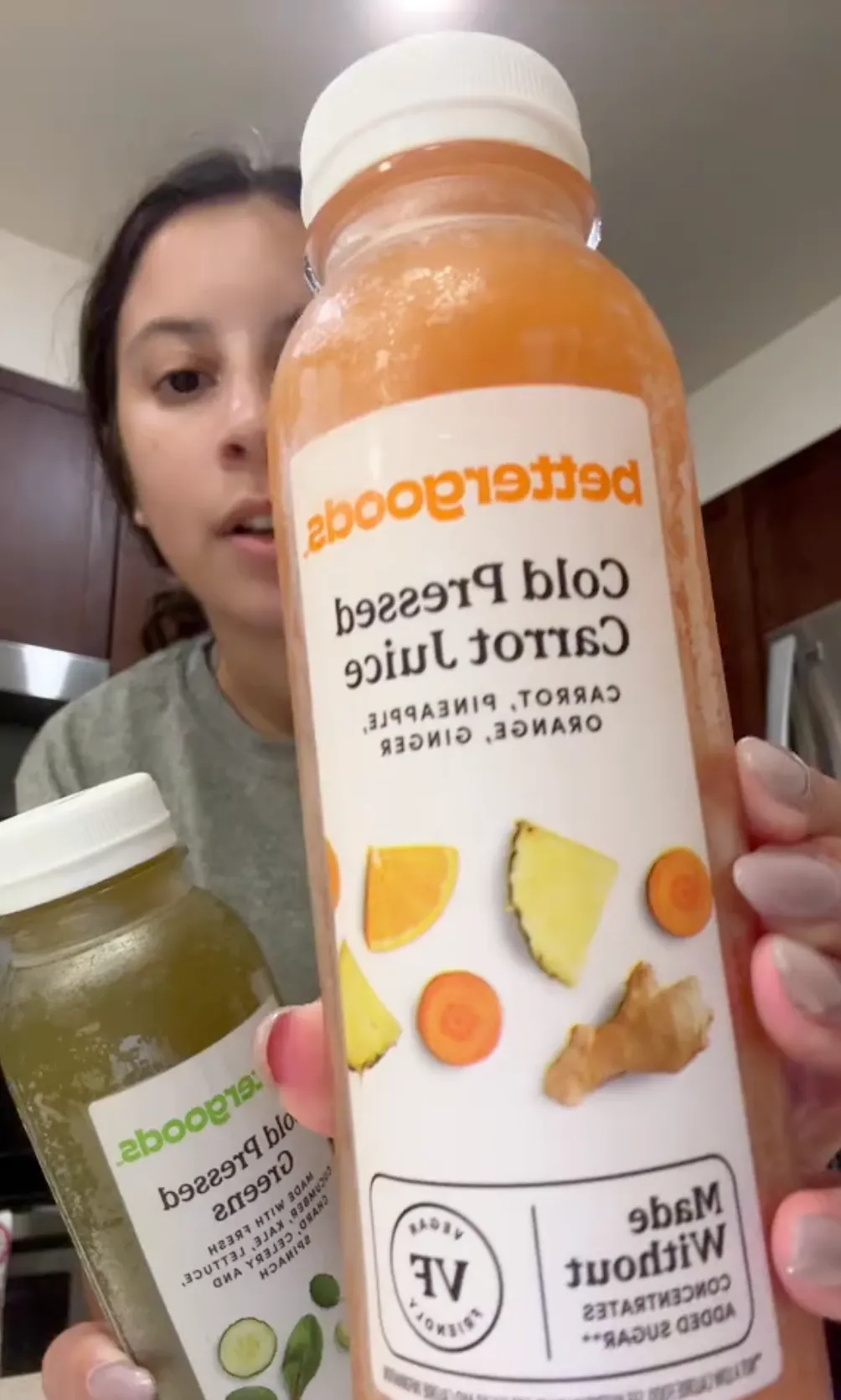 woman holding up cold pressed juices from Walmart's Bettergoods brand