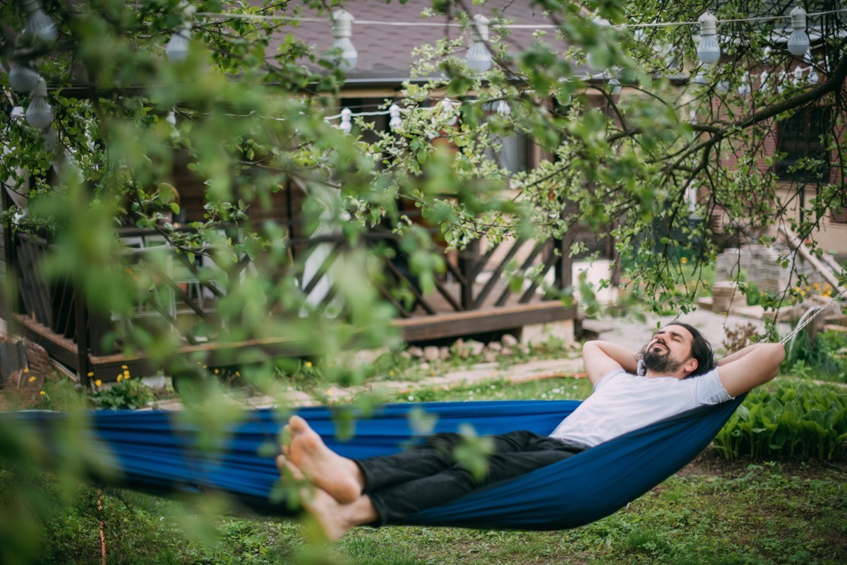 Man on a hammock in the backyard