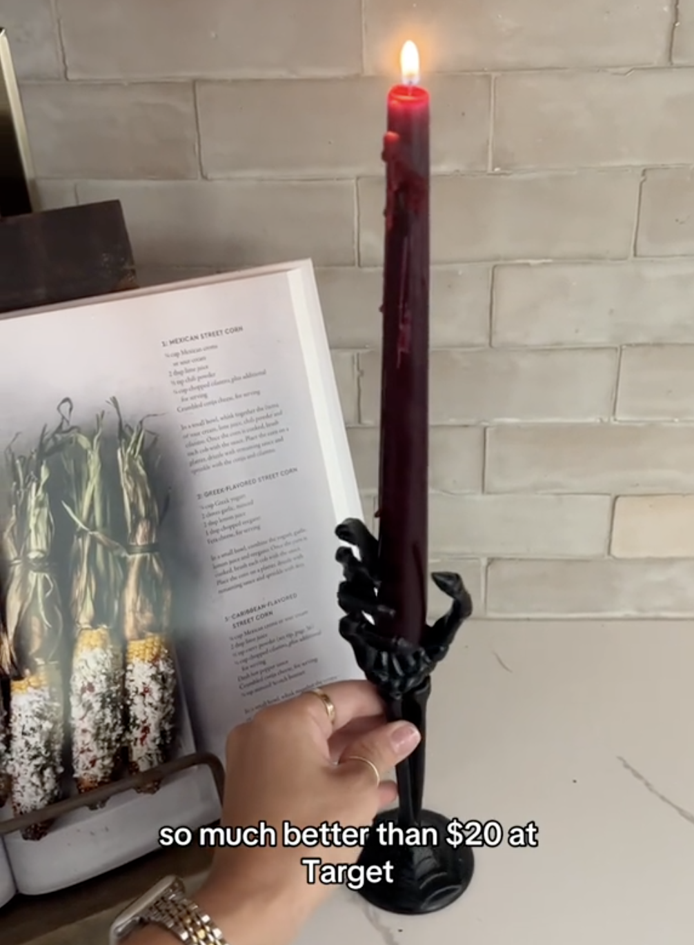 skeleton hand taper candle holder on a counter