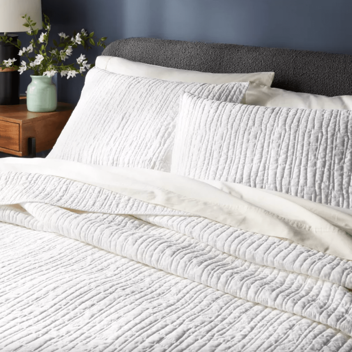 Cropped image of a bed with white quilt