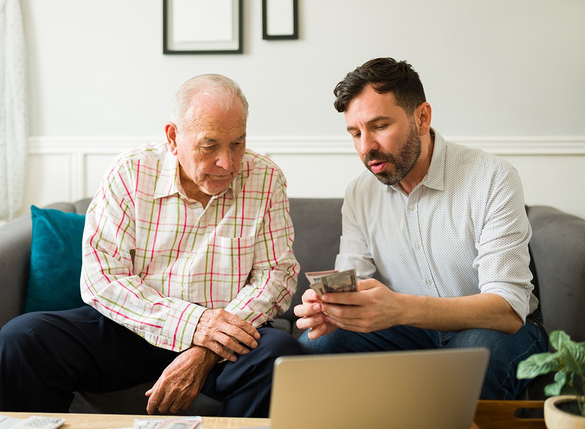 A senior man gives his adult son cash