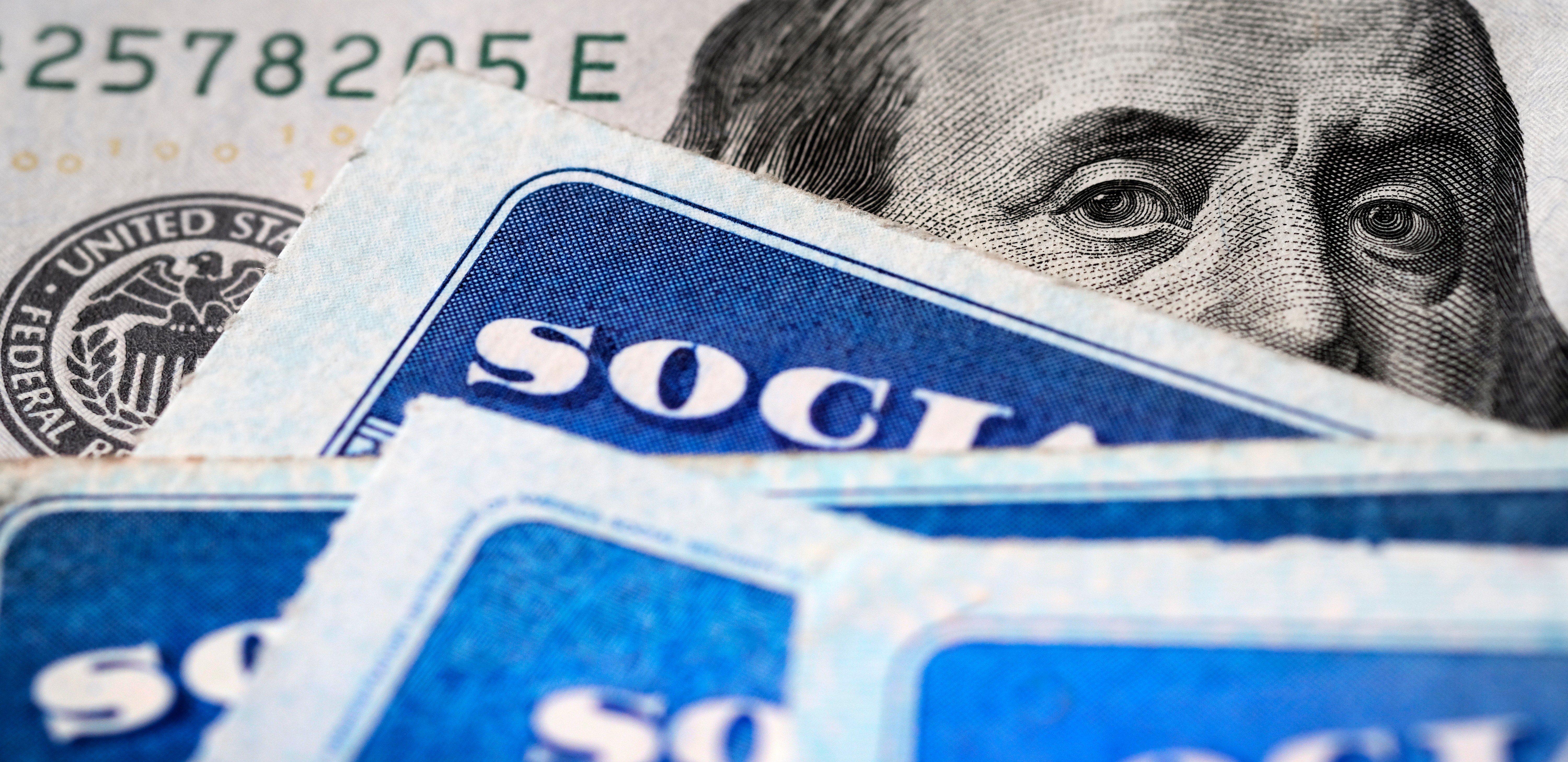 Several Social Security Cards on a US United States one hundred dollar bill 