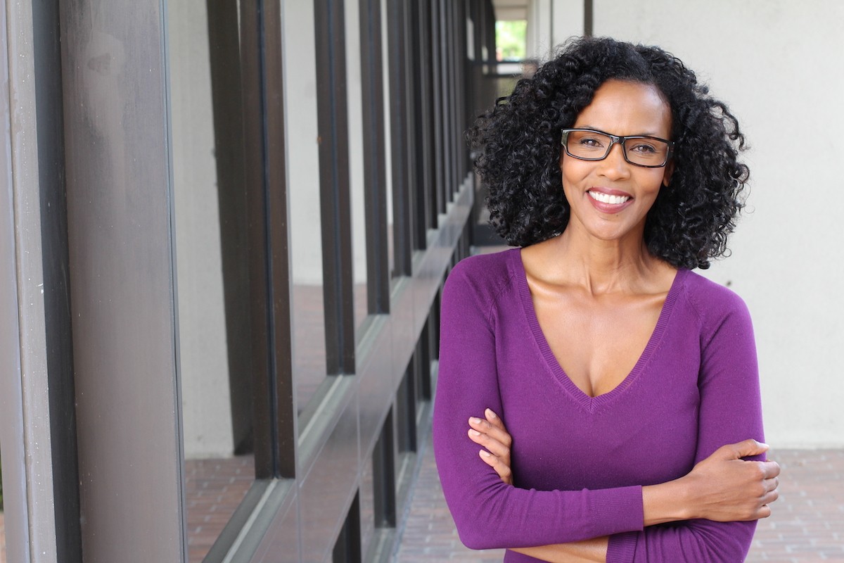 Portrait of a businesswoman smiling and wearing a purple v-neck sweater