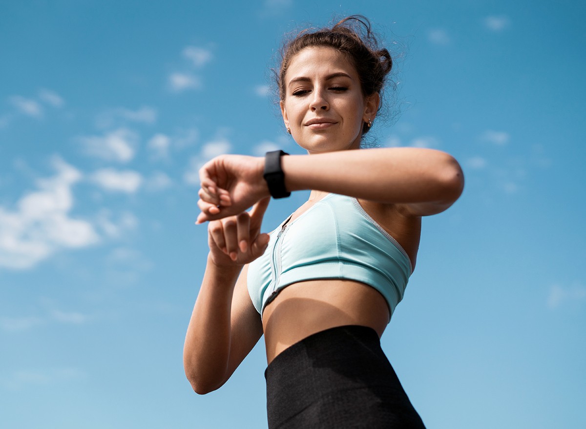 A woman looking at her fitness tracking watch during a workout