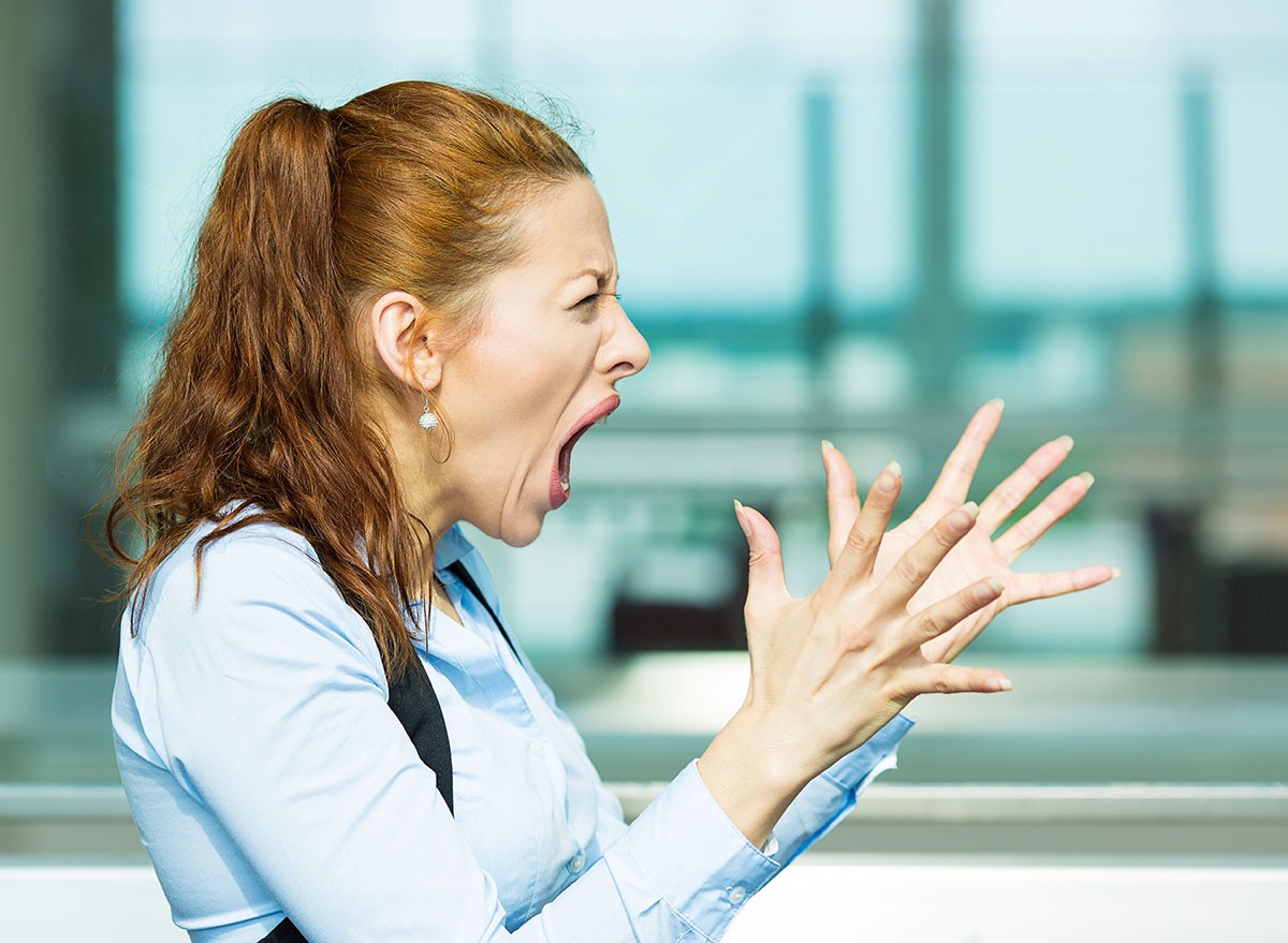 A woman raising her hands and screaming in anger