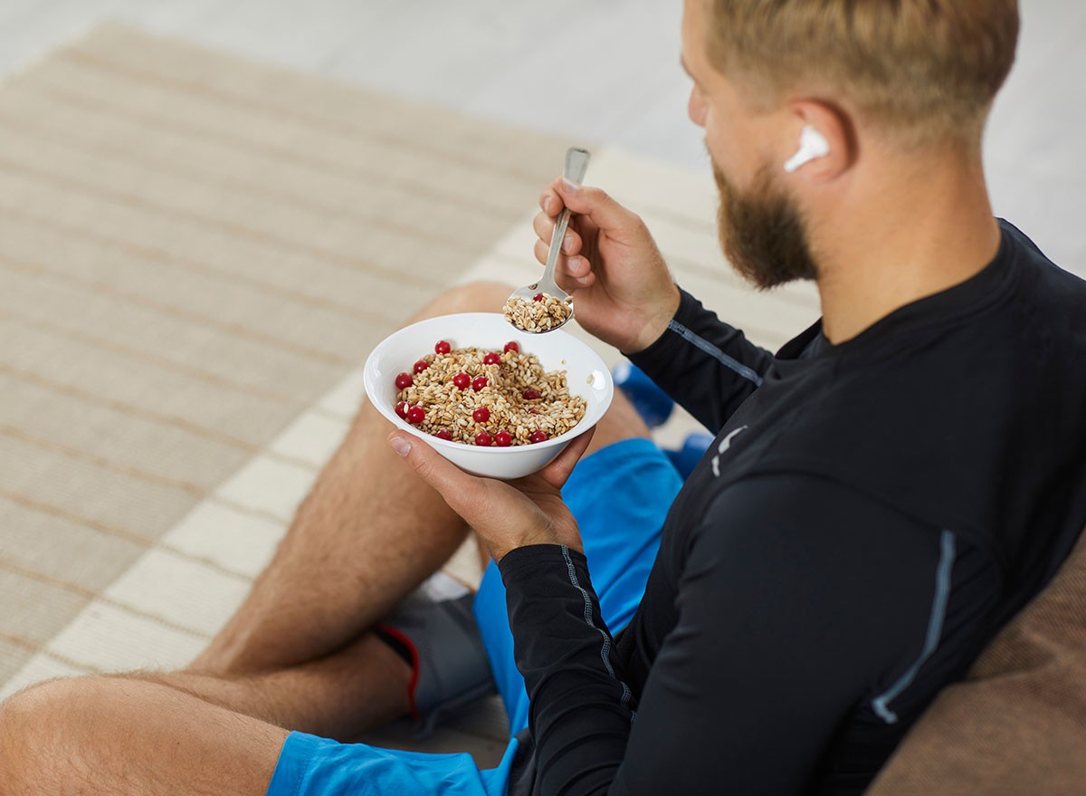 Man sitting on the floor eating a bowl of high-fiber cereal