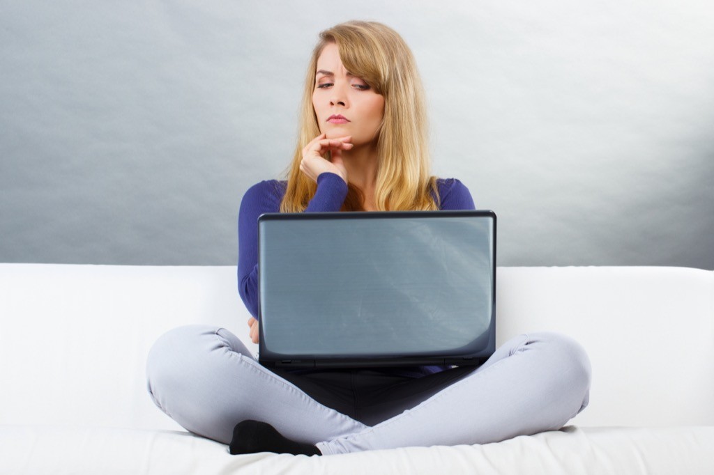 Woman using a laptop looking skeptical