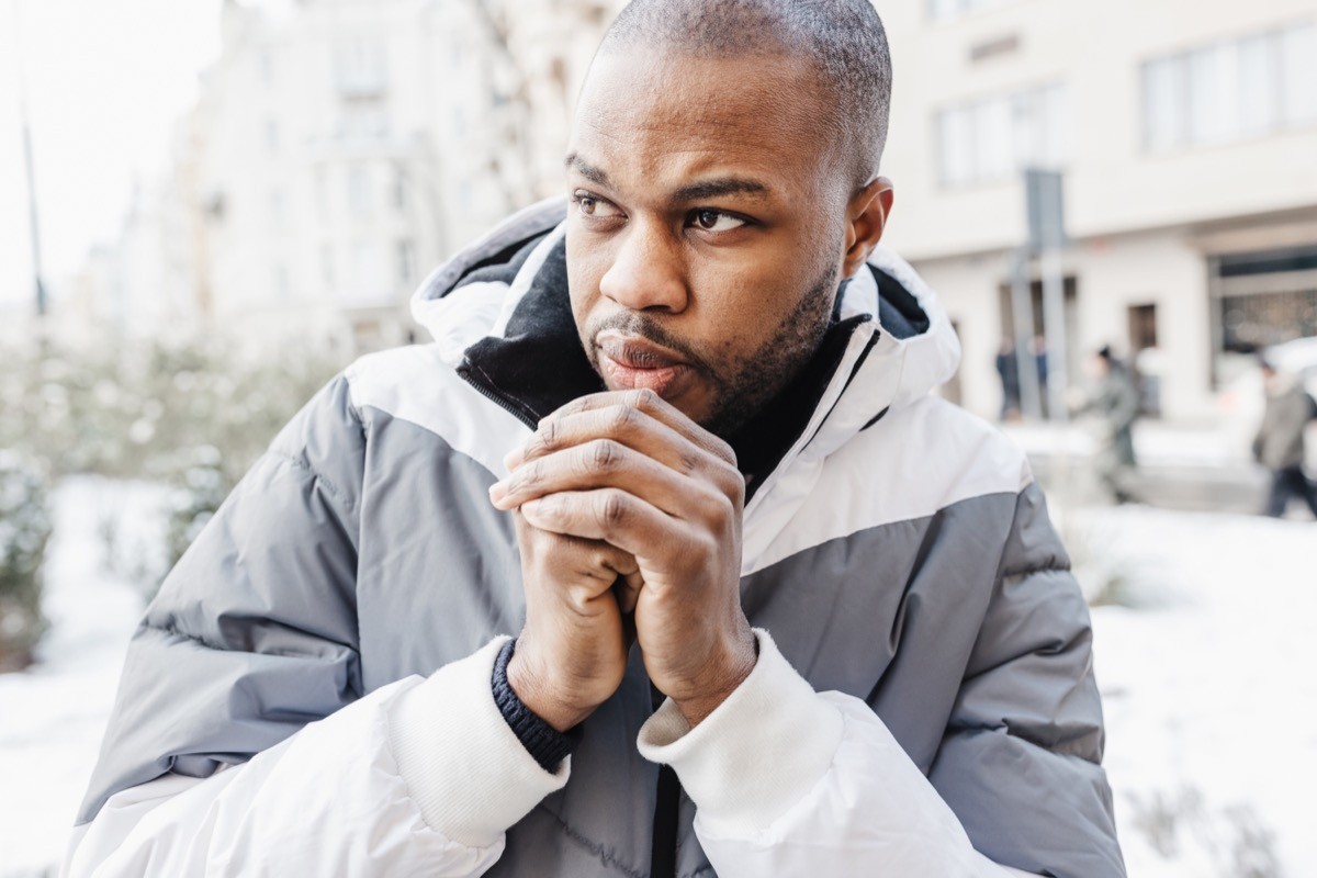 A man feeling cold, outside in the snow