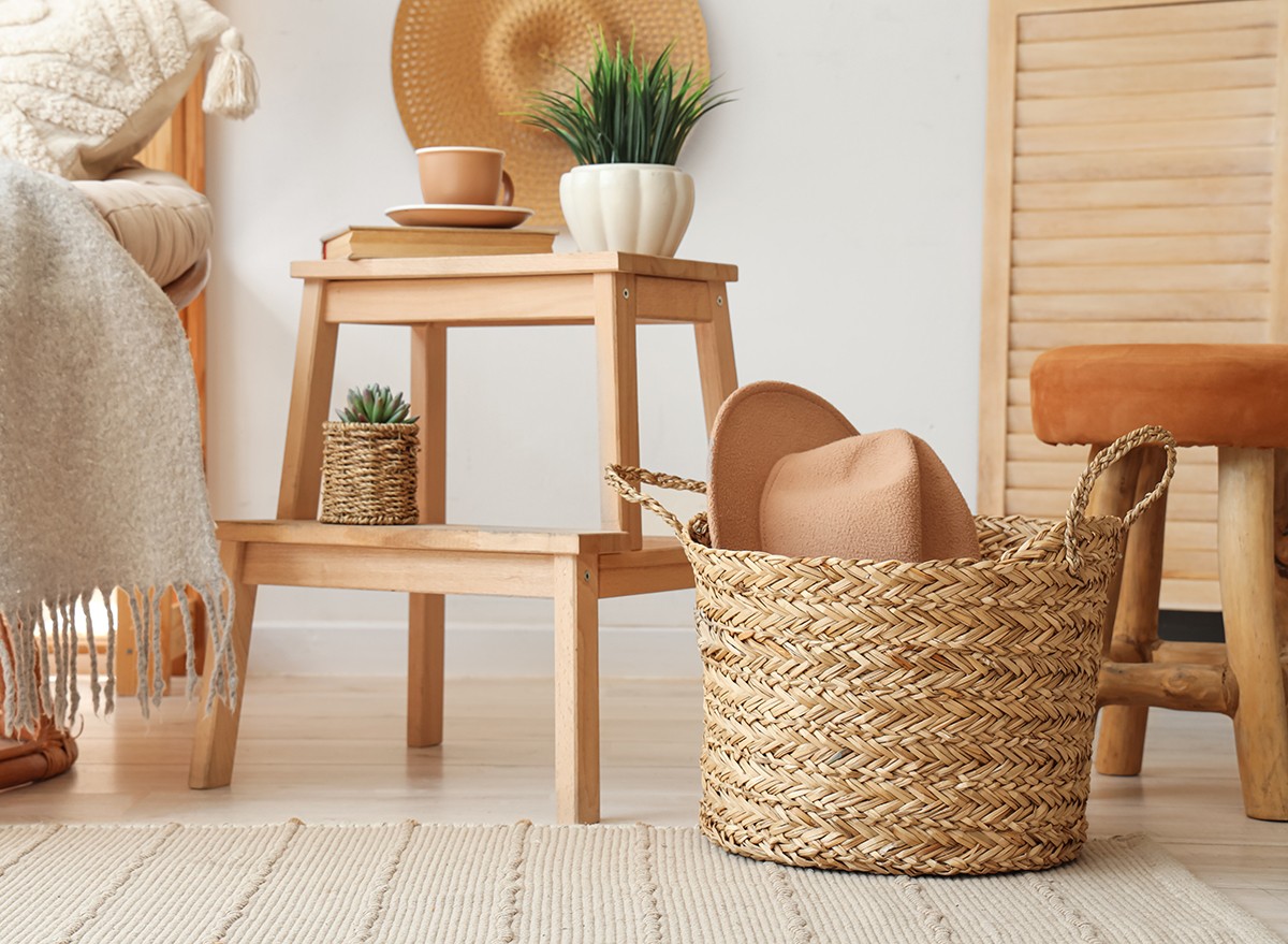 A wicker storage basket on the floor of a bedroom