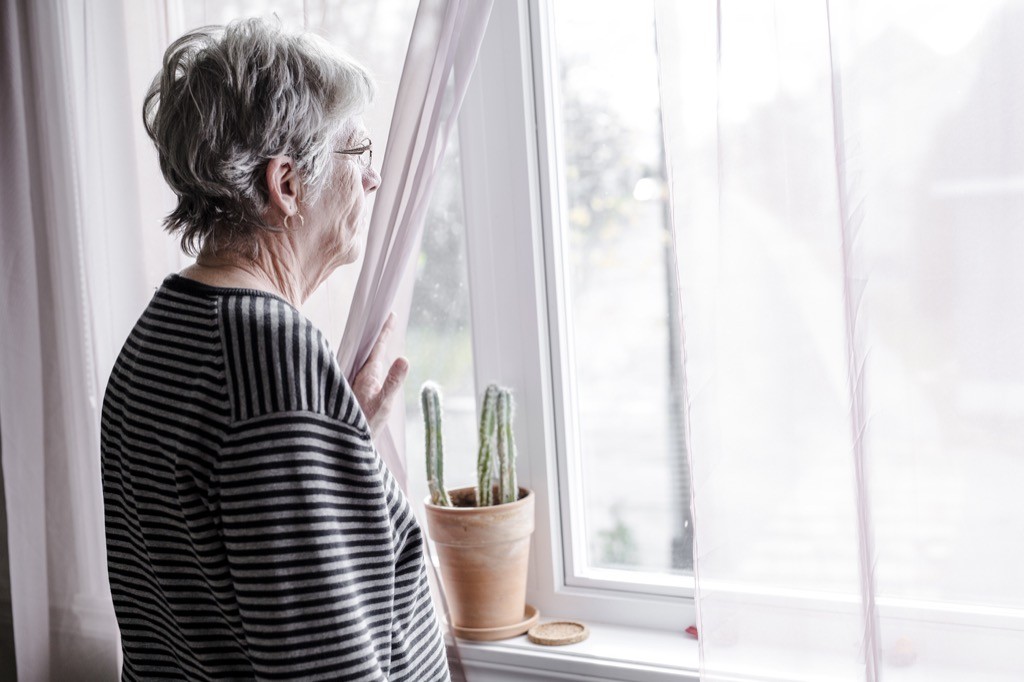 Senior woman looking out the window.