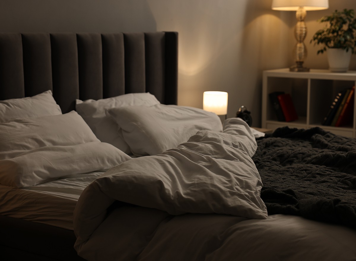 A comfortable bed in a dark room creating a sleep-friendly environment