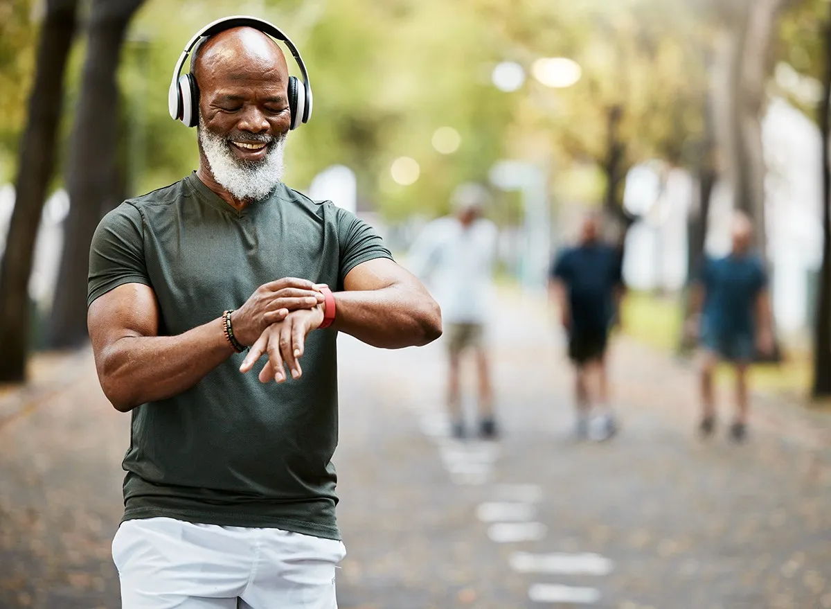 A man listens to music on headphones while outside walking