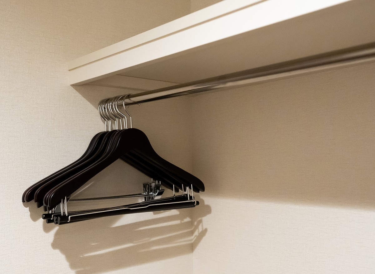 A closet rod installed under a shelf in a closet
