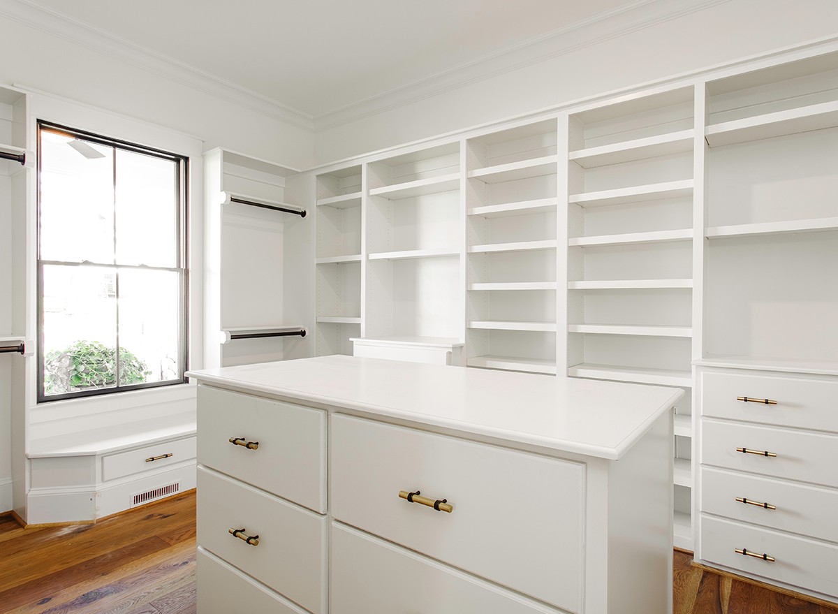 A closet with a dresser island in the middle