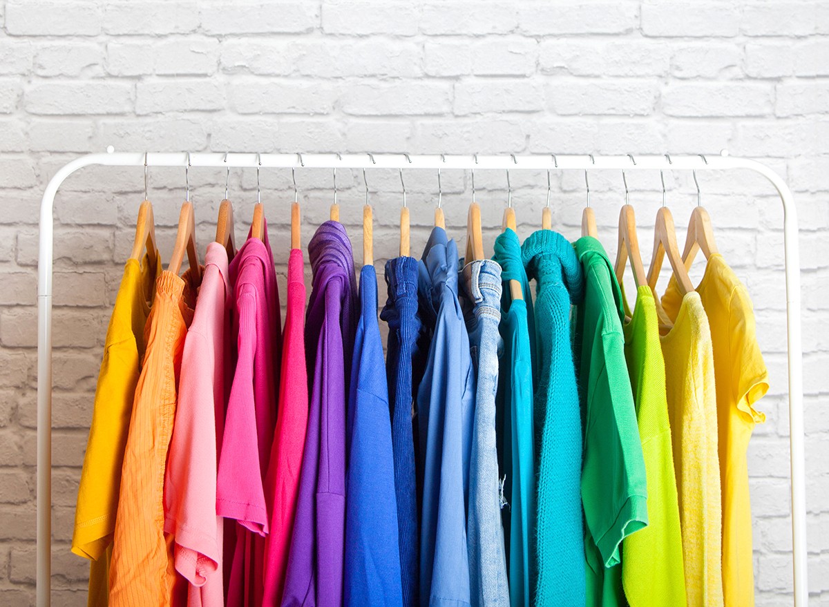 Color coded clothing hanging in a closet